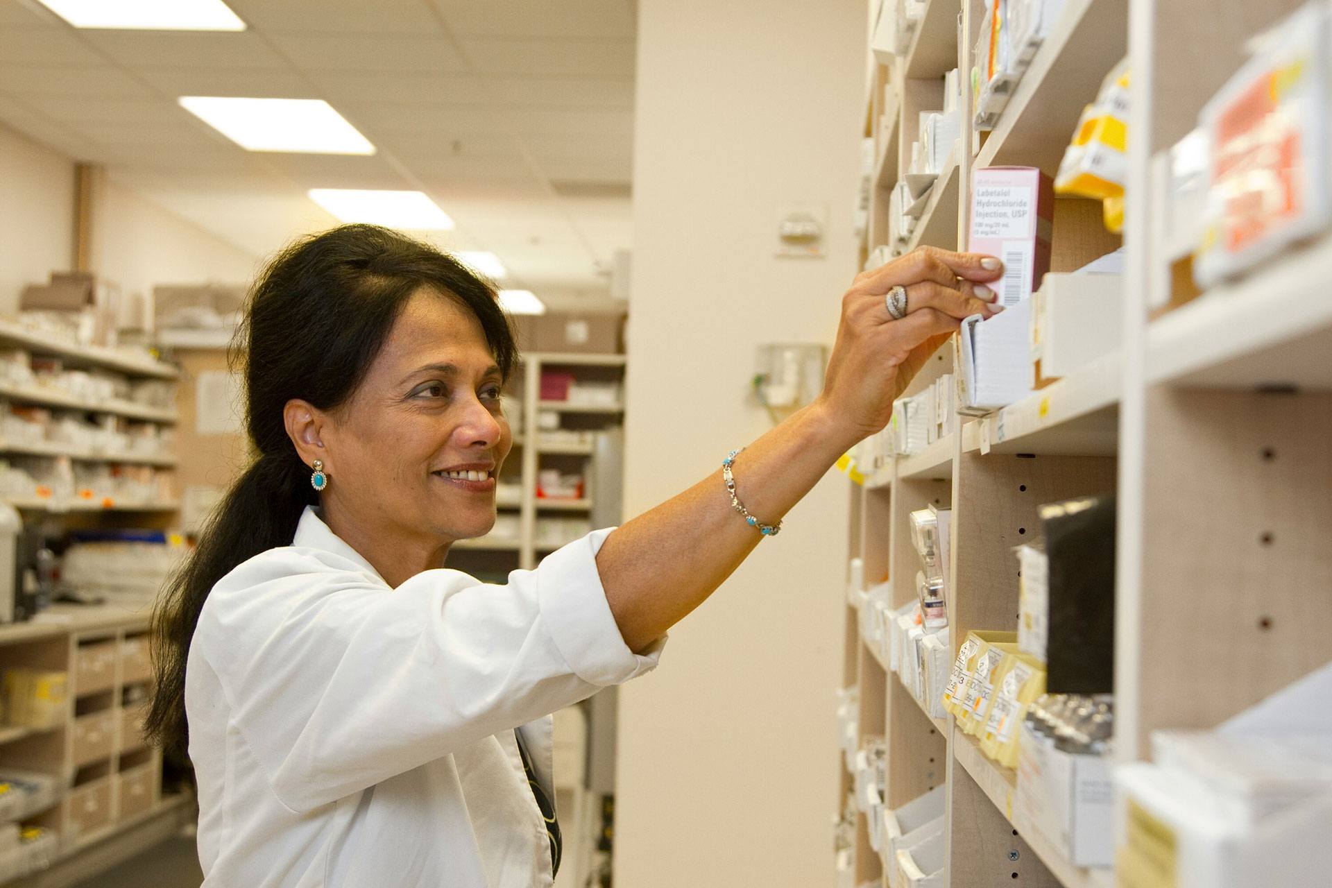 pharmacist taking item from shelf